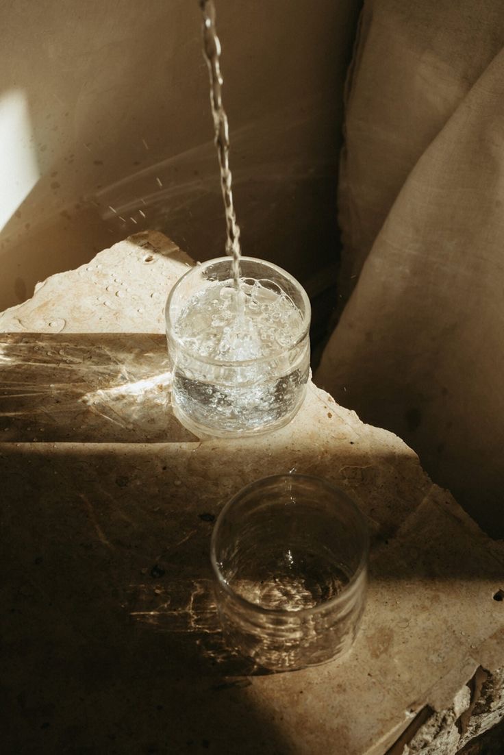 pouring water into one glass, with another glass empty